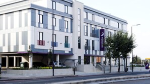 Un edifici modern amb façana plana, grans finestres i un notable banner morat.