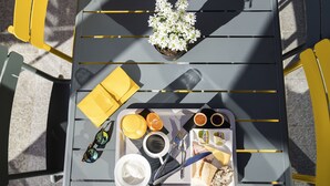 Une table sur laquelle se trouve un plateau contenant de la nourriture, des boissons et une plante.