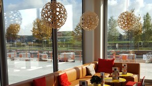 Un intérieur moderne avec un canapé, des tables et des luminaires suspendus.
