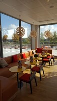 A modern interior with a sofa, tables, and hanging light fixtures.