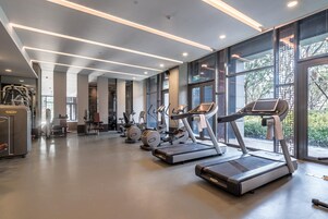 Un gimnasio moderno con cintas de correr, elípticas y equipo de pesas.