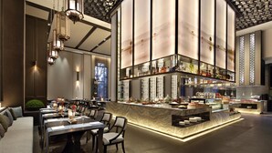 A modern restaurant with a bar area, seating arrangements, and a decorative ceiling.