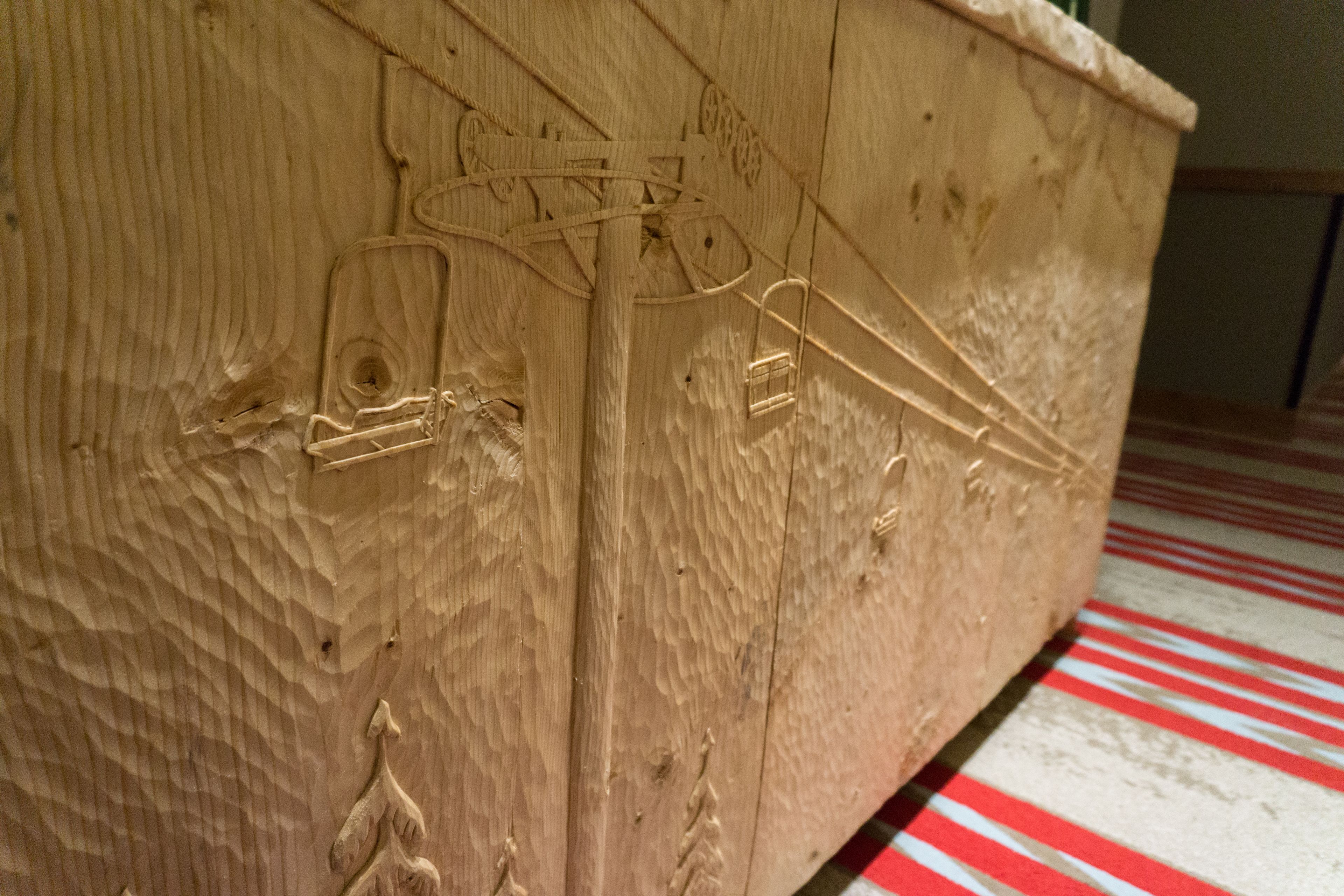 Un mueble de madera con tallas intrincadas y un tirador.