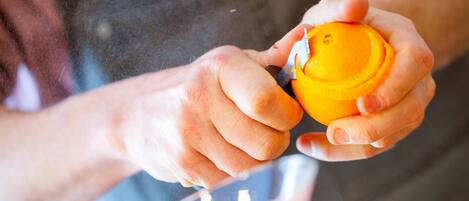 A person squeezing an orange.