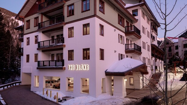 A multi-story hotel with balconies and a sign reading "THE BLØKE".