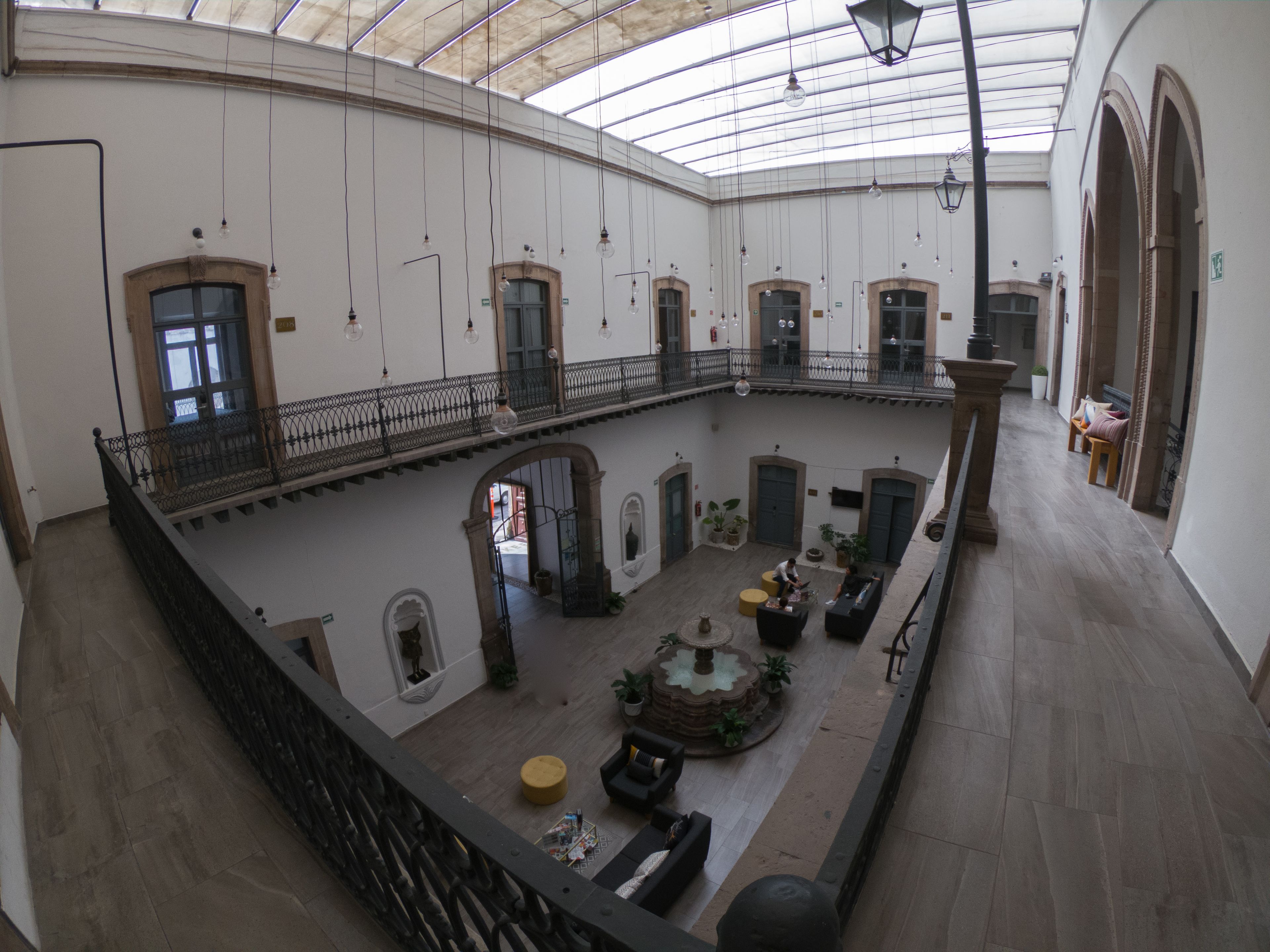 A spacious atrium with a high ceiling, multiple balconies, and a central fountain.
