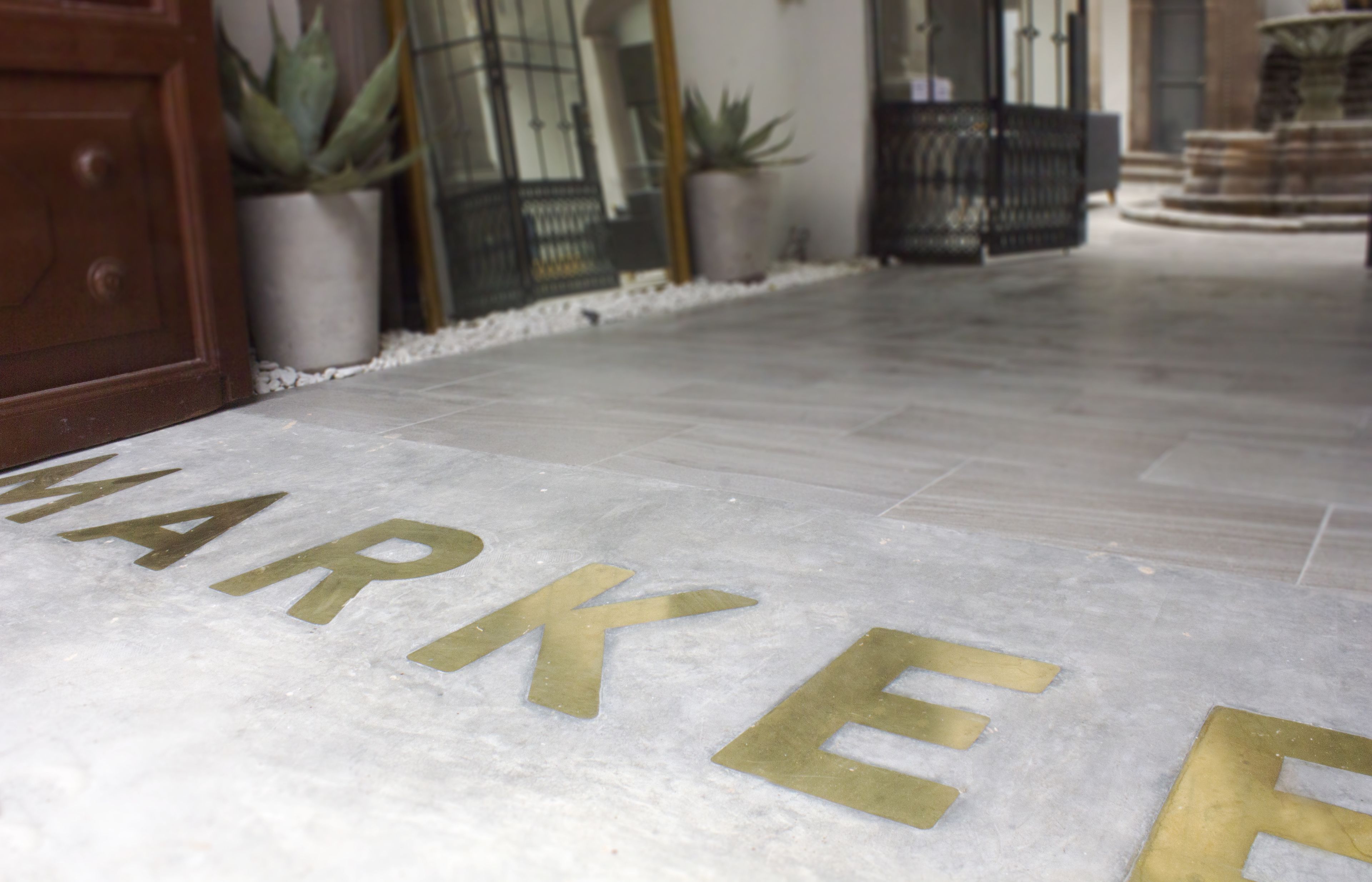 A marble floor with the word "MARKER" engraved in gold letters.