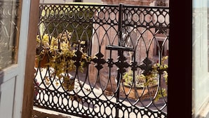 A balcony with a wrought iron railing and a view of a historic building with a bell tower. - Markee Hotel Boutique (Querétaro)