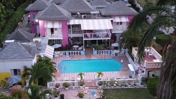 A large house with a swimming pool, multiple balconies, and a well-maintained garden. - PinkHibiscus Guest House (Montego Bay)