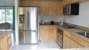 Una cocina moderna con armarios de madera, electrodomésticos de acero inoxidable y encimera de granito.