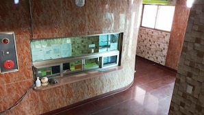 A reception area with a marble wall, a glass display case with papers, and a small statue on the counter. - Mirim Motel (Gyeongju)