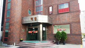 A brick building with a glass entrance, a sign reading "Motel", and a small step leading to the entrance. - Mirim Motel (Gyeongju)