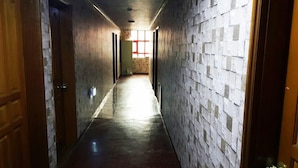 A narrow hallway with a tiled wall and a wooden door on the left. - Mirim Motel (Gyeongju)