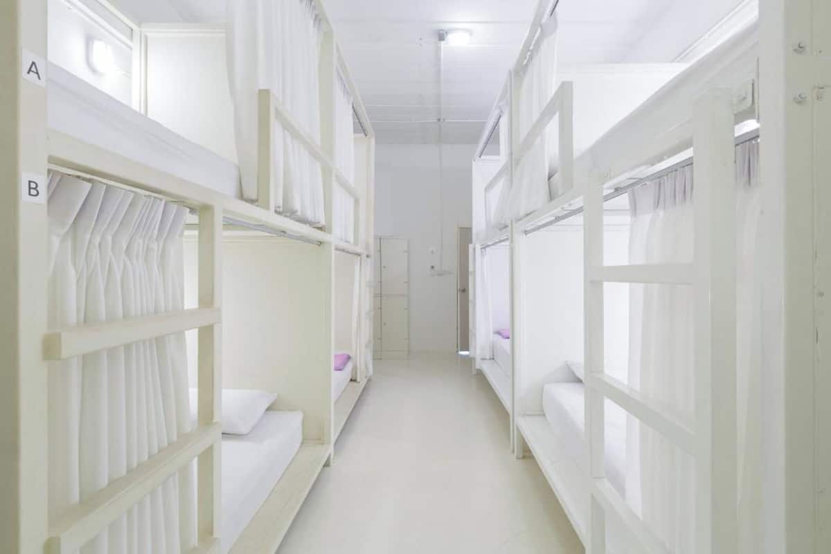A corridor with bunk beds labeled A and B, leading to a door at the end.