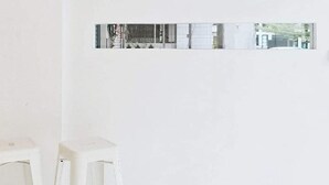 A minimalist interior with geometric wall art and a reflective strip. - HAO HOSTEL PHUKET (Phuket)