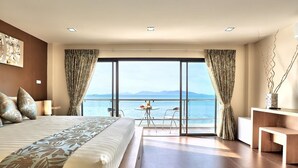 Una habitación de hotel moderna con una cama grande, un escritorio y vista al mar.