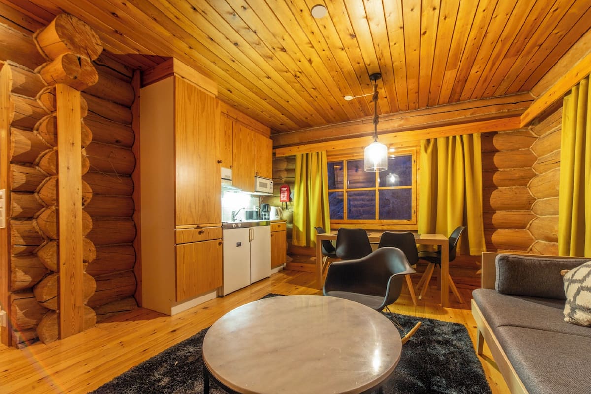 L’intérieur d’une cabane en rondins comprend un coin repas, une cuisine et un espace salon.