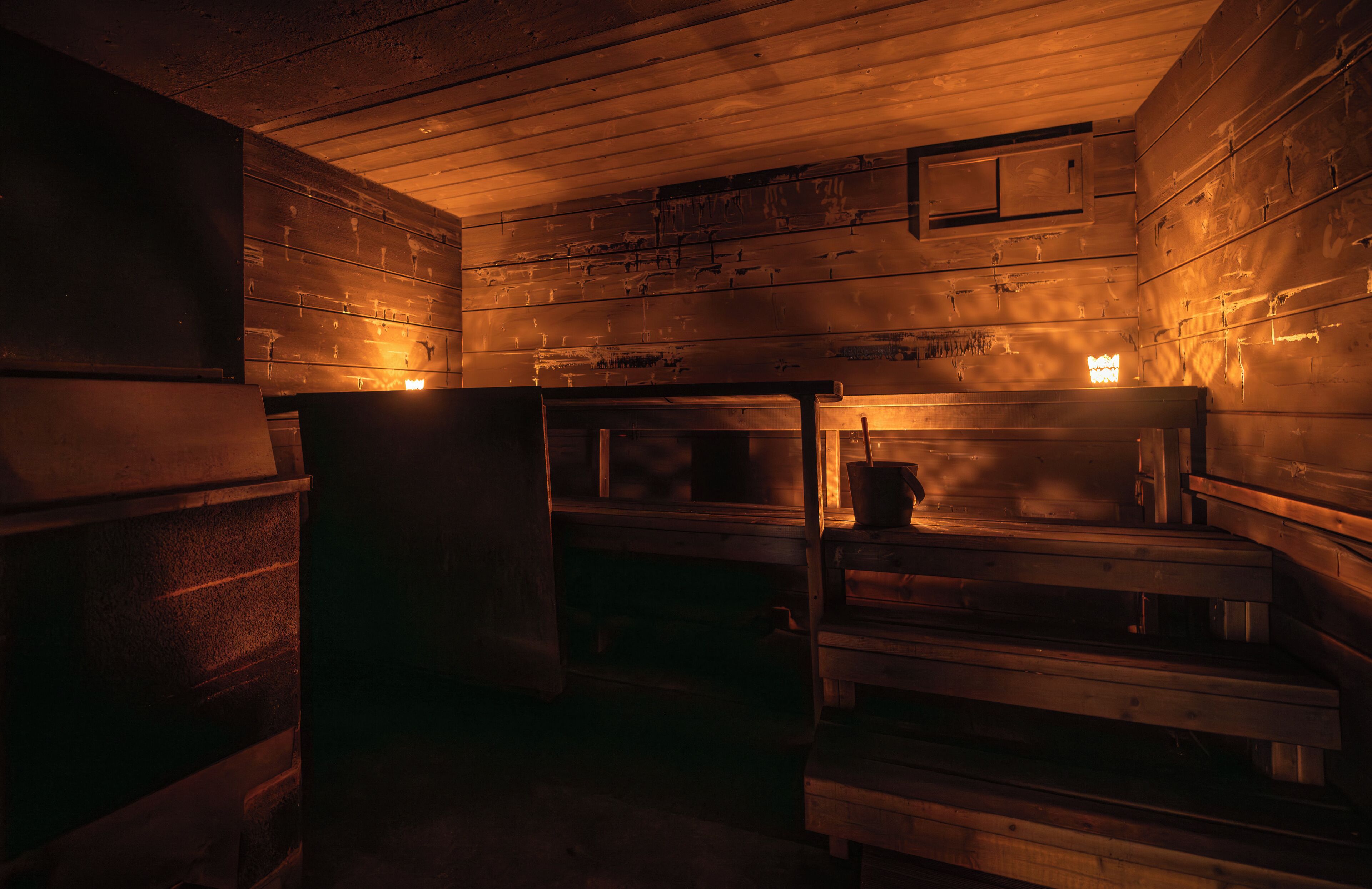 A dimly lit wooden cabin with bunk beds and a small table.