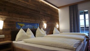 Quarto de hotel com duas camas, peseira de madeira, luminárias fixadas na parede e um quadro.