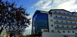 A hotel with a modern glass facade and a sign reading "The Corner Hotel." - The Corner Hotel (Sincan)