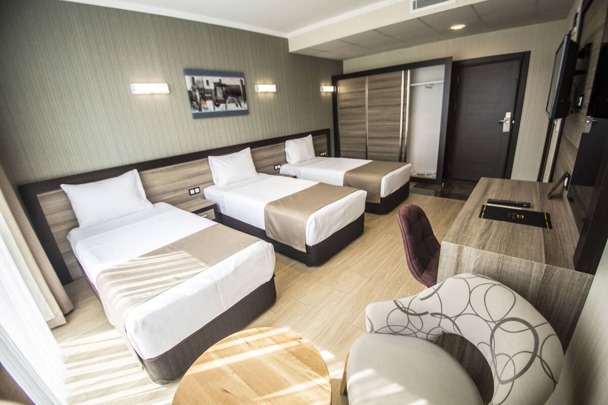 Una habitación de hotel con dos camas, un escritorio, una silla y un televisor.