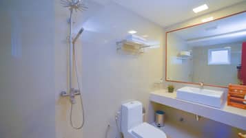 Un baño moderno con ducha, inodoro, lavamanos y espejo.