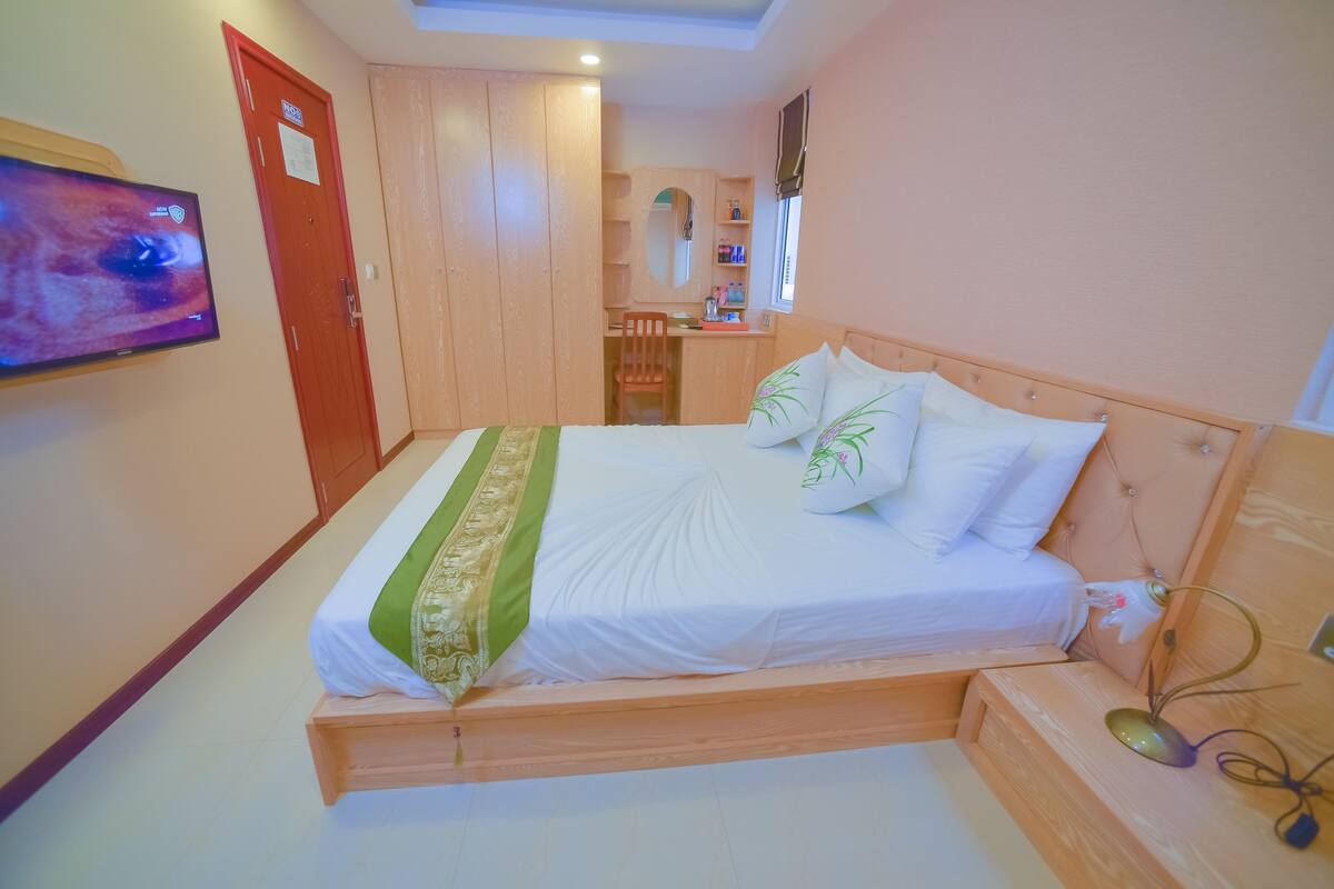 Ein Schlafzimmer mit einem Bett, einem Schreibtisch und einem Fernseher.