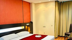 A hotel room with a large bed, two bedside tables, a desk, and a chair. - Hotel La Cantueña (Fuenlabrada)