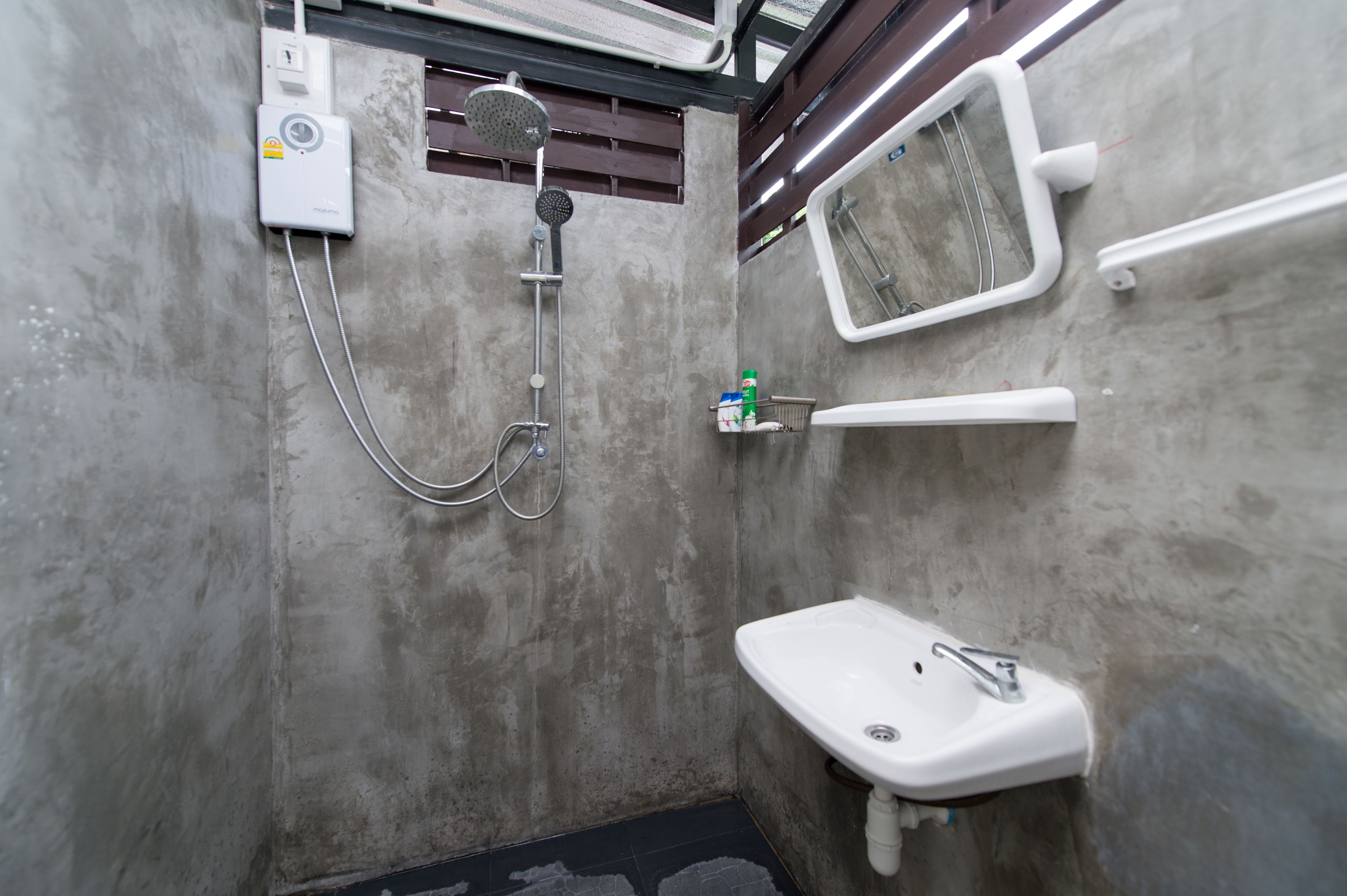 A bathroom with a shower, a sink, and a mirror.