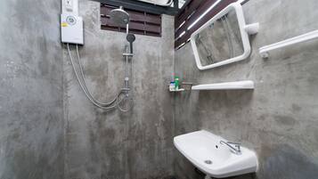 A bathroom with a shower, a sink, and a mirror.