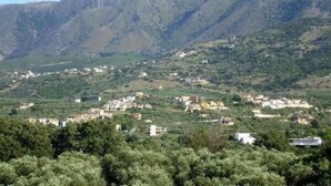 A mountainous landscape with scattered buildings, likely a rural or semi-rural area. - Pinelopi Apartments (Apokoronas)