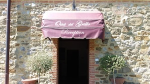 A stone building entrance with a marquee sign reading "Oasi del Grillo Reception". - Oasi del grillo (Castelnuovo Berardenga)