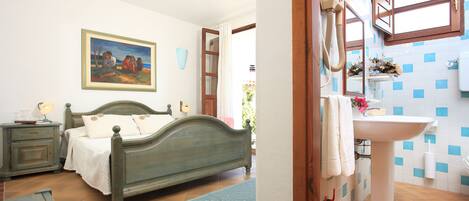 Un dormitorio con cama, mesita de noche y un cuadro en la pared.