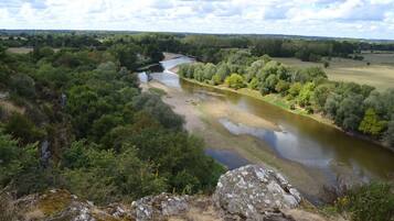 A river winding through a forested landscape with rocky outcrops in the foreground.