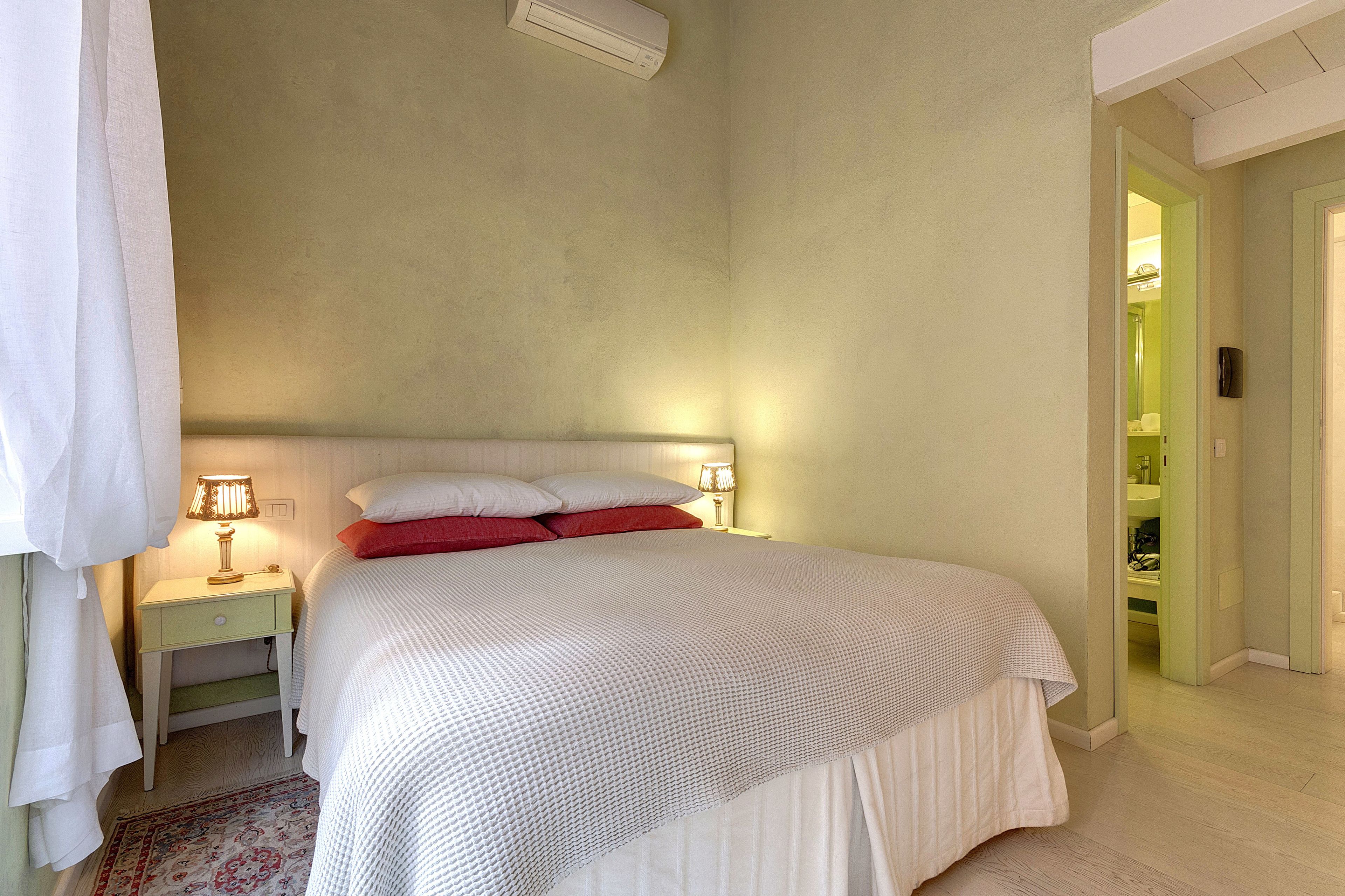 A bedroom with a bed, nightstands, and a night lamp.