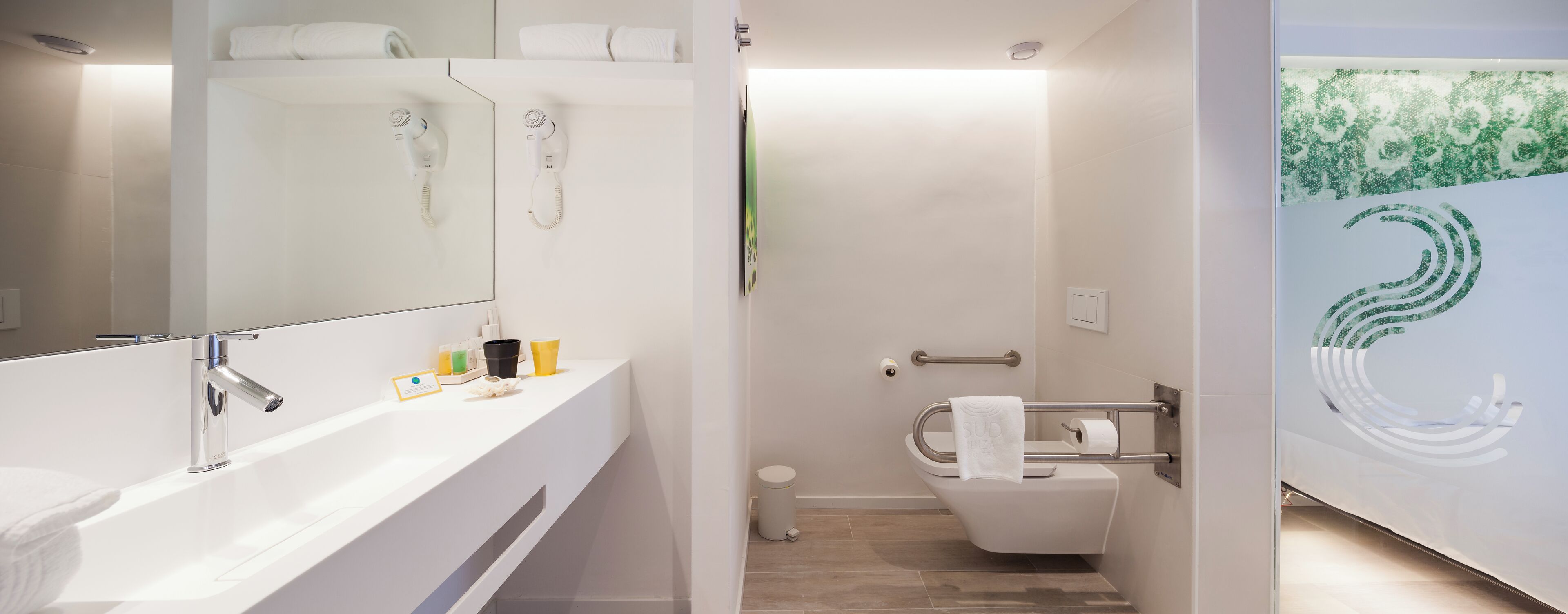 A modern bathroom with a white vanity, a shower area, and a toilet.