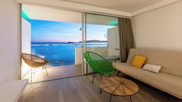 Une chambre moderne avec un balcon, un canapé, deux fauteuils et une petite table.