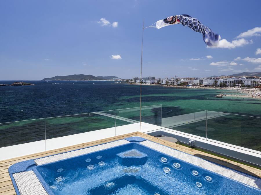 Un jacuzzi en un balcón con vista al mar y a la playa.