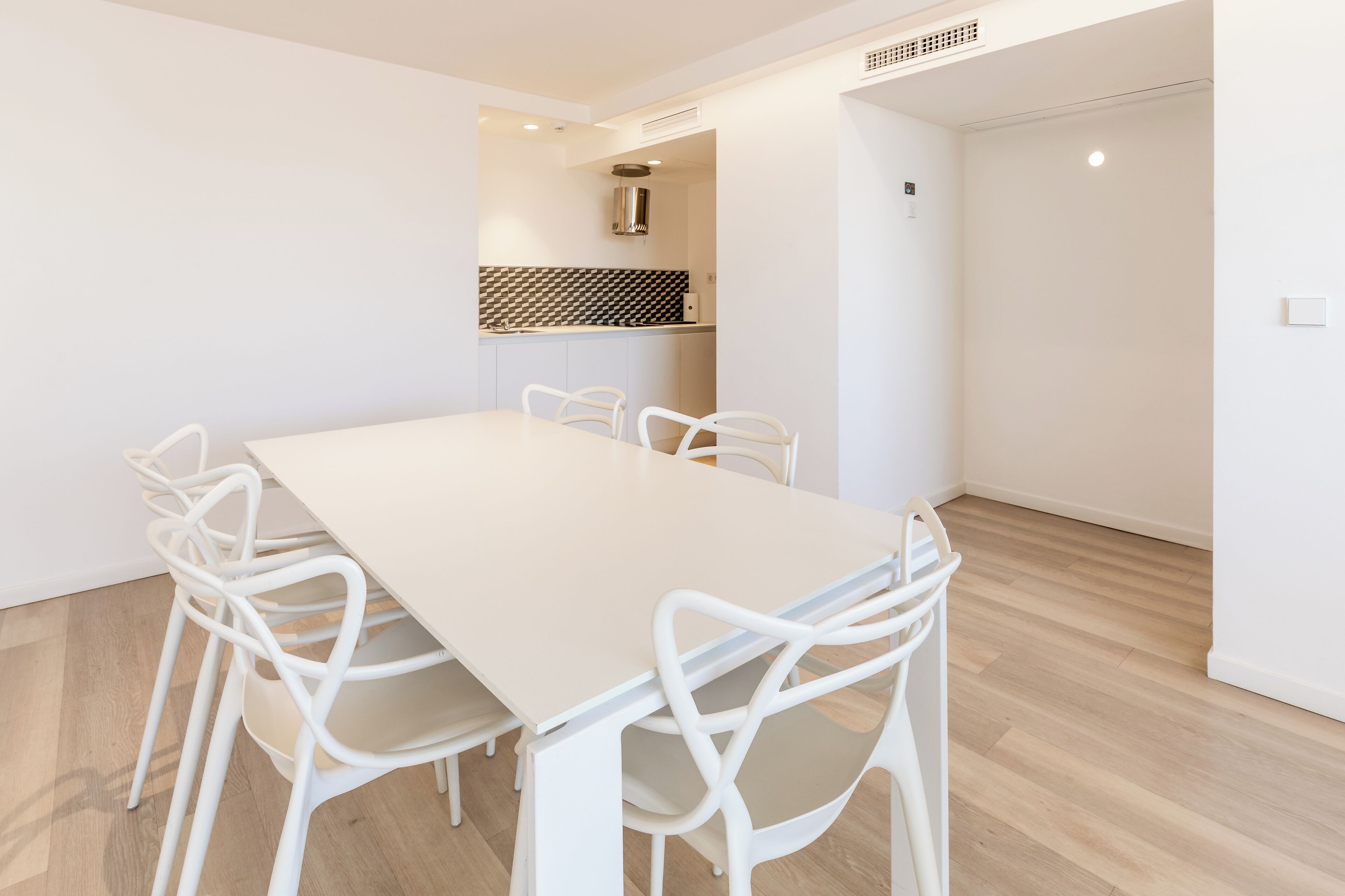 Una cocina moderna con armarios blancos y un salpicadero blanco y negro.