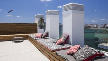 Terraza en la azotea con zona de estar, vistas al mar y una cometa volando.