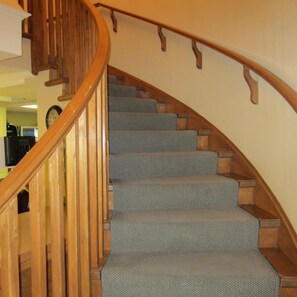 Una escalera de madera con escalones alfombrados y barandilla.