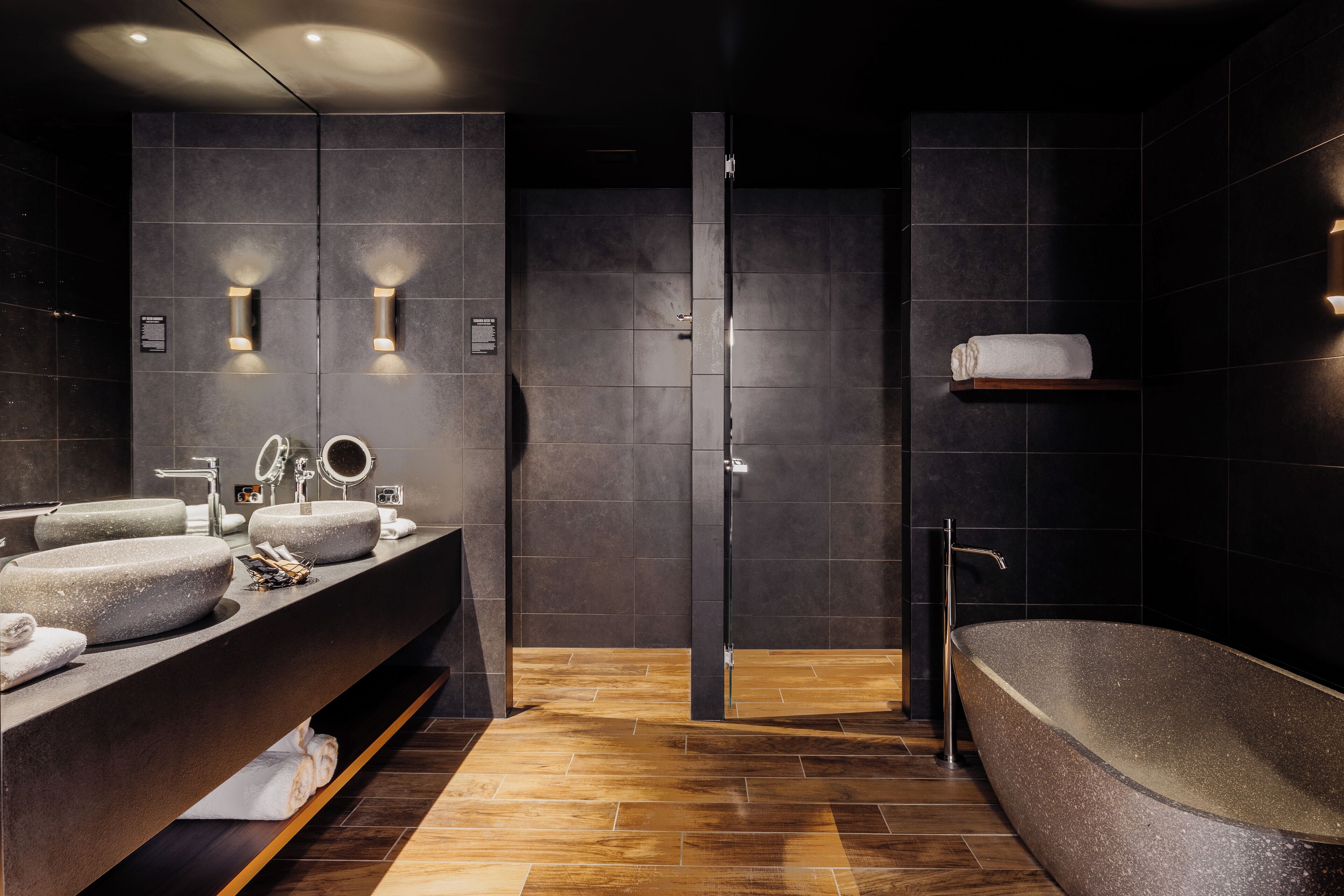 Un baño moderno con una bañera grande, dos lavamanos y una zona de ducha.