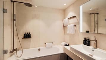 A modern bathroom with a bathtub, a shower, and a sink.