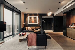 Un salon moderne avec un canapé, une table basse et des œuvres d’art accrochées au mur.