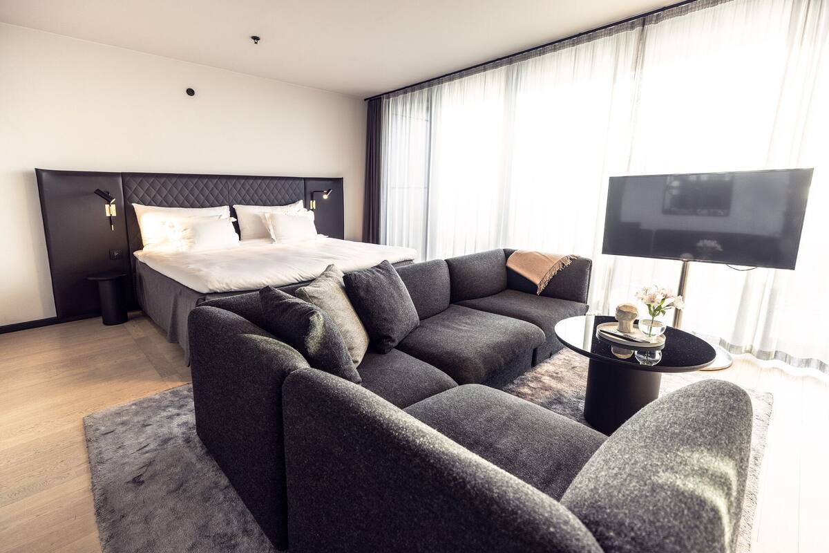 Suite | Sengetøy av topp kvalitet, dundyner, minibar og safe på rommet