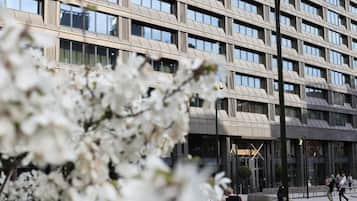 En modern byggnad med ett rutmönster av fönster och en central entré.