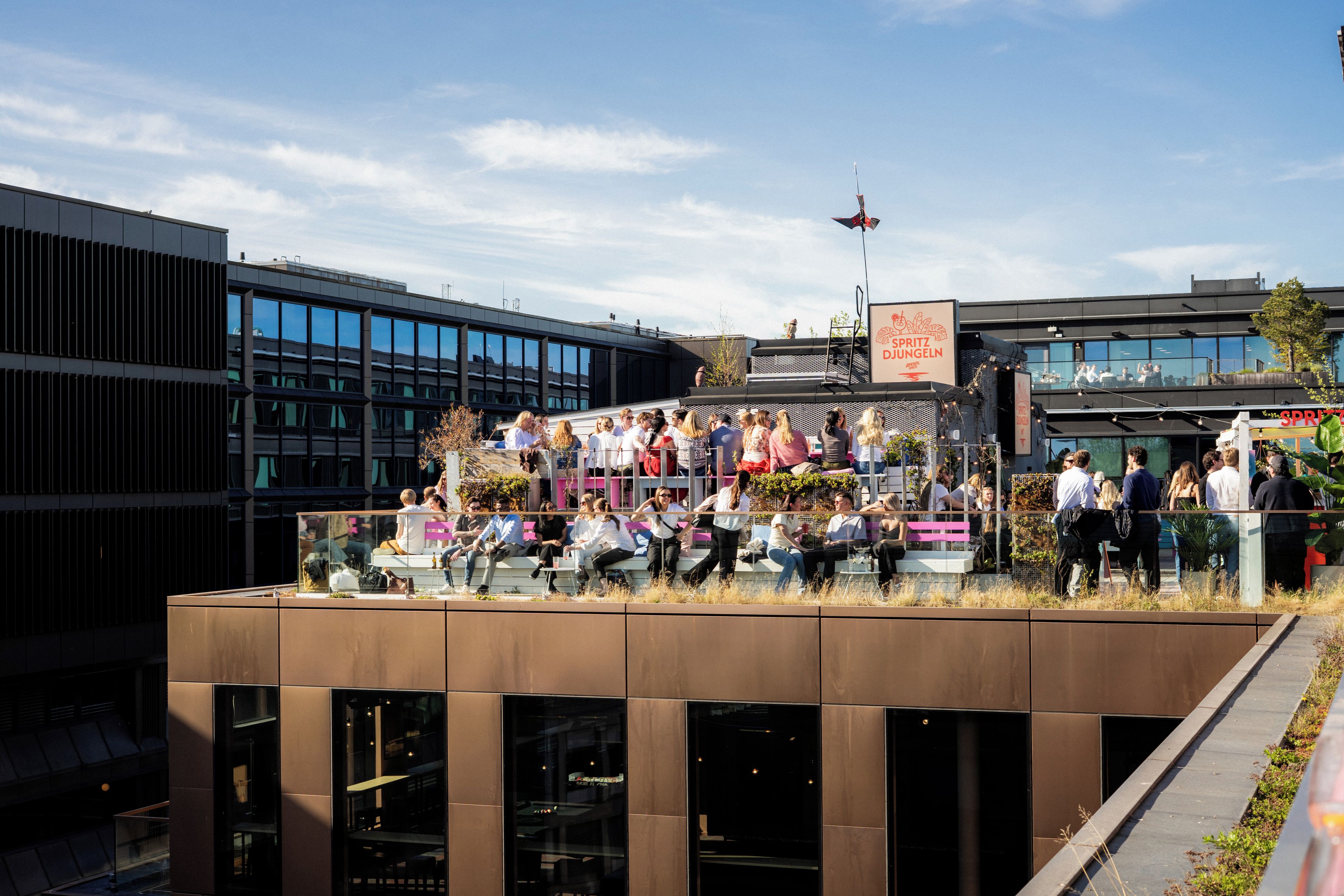 A modern building with a glass facade and a rooftop event space.