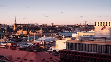 A cityscape with historic buildings, a prominent church spire, and a modern building with a flag.