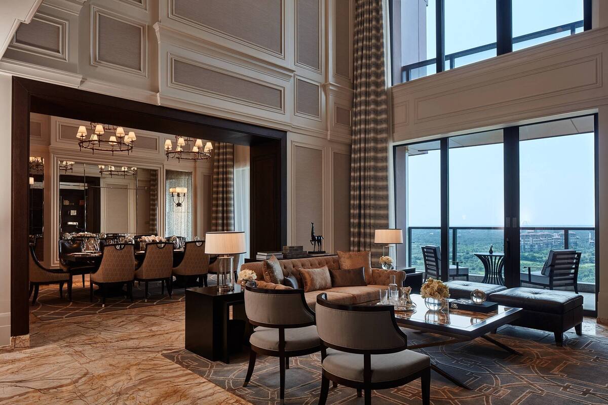 A spacious lobby with a high ceiling, a dining area, and a seating area with a view.