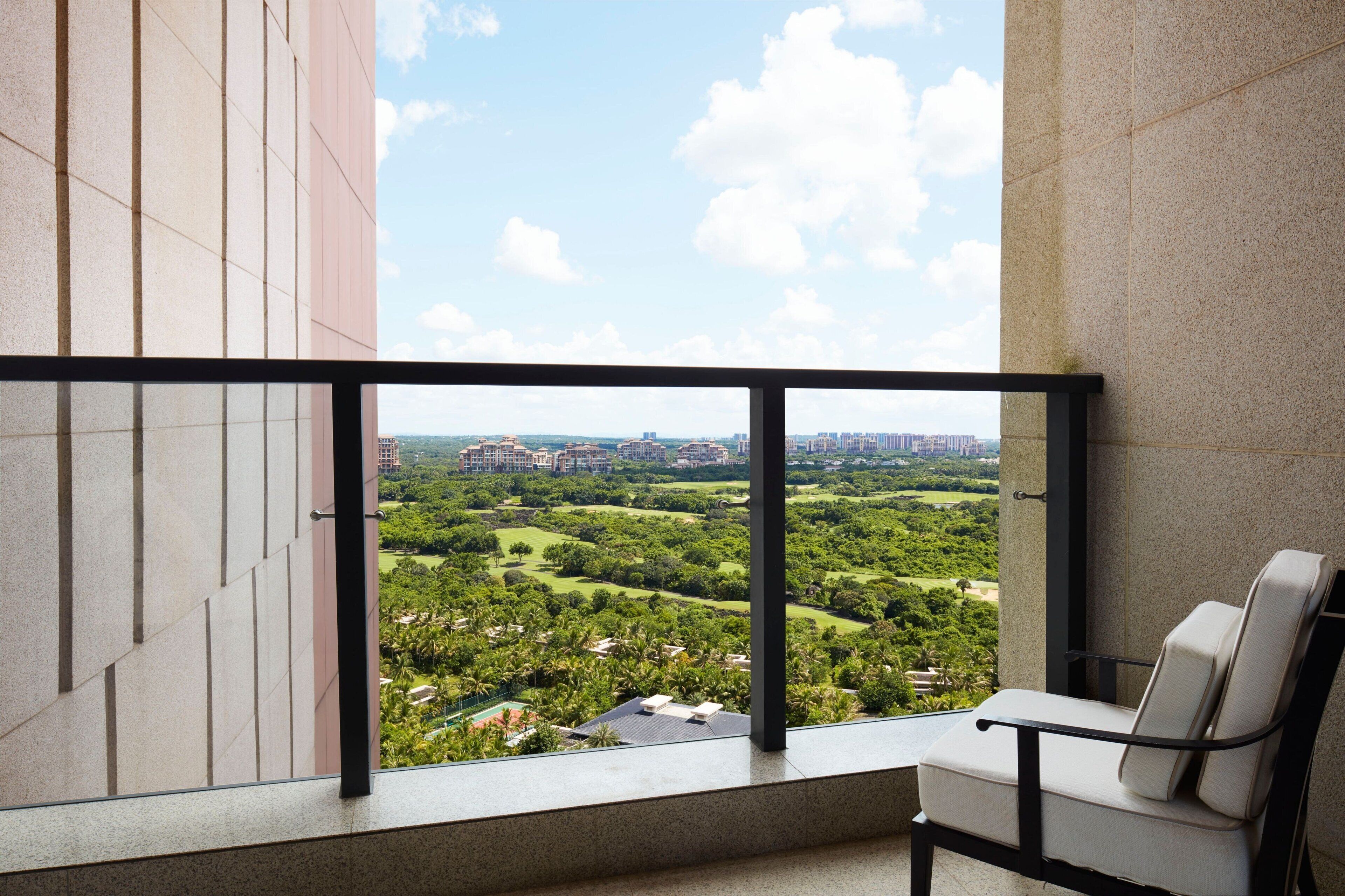 A balcony with a view of a park and buildings.